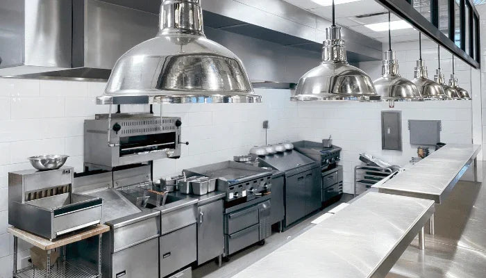 Professionelle Gastronomie-Küche mit Edelstahlgeräten, Kochfeldern und Dunstabzugshauben